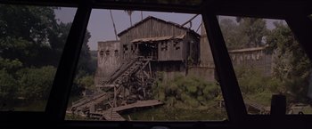 Movie still from “Anaconda” (1997), directed by Luis Llosa – An old building with a wooden structure on the side of it; Extreme Wide shot, High angle