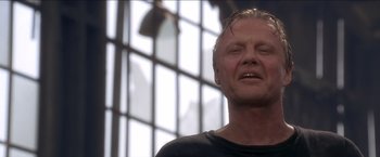 Movie still from “Anaconda” (1997), directed by Luis Llosa – An older man is looking at the camera; Close Up shot, Low angle