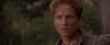 Movie still from “Anaconda” (1997), directed by Luis Llosa – A person wearing a shirt and bow tie; Close Up shot, Over the shoulder angle