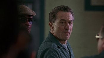 Movie still from “Analyze That” (2002), directed by Harold Ramis – A person wearing a hat and glasses; Close Up shot, Over the shoulder angle
