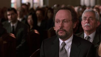 Movie still from “Analyze That” (2002), directed by Harold Ramis – A man in a suit and tie in front of an audience; Close Up shot, Low angle