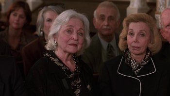 Movie still from “Analyze That” (2002), directed by Harold Ramis – A group of people standing next to each other in a room; Close Up shot, Low angle