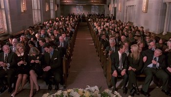 Movie still from “Analyze That” (2002), directed by Harold Ramis – A large group of people sitting in a church; Wide shot, High angle