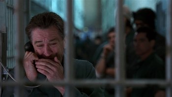 Movie still from “Analyze That” (2002), directed by Harold Ramis – A man sitting in front of a jail cell crying; Close Up shot, Low angle
