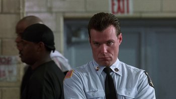 Movie still from “Analyze That” (2002), directed by Harold Ramis – A man in a uniform is standing in front of a building; Close Up shot, Low angle