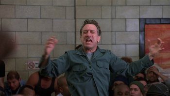 Movie still from “Analyze That” (2002), directed by Harold Ramis – A man in a crowd of people with his mouth wide open; Medium shot, Low angle