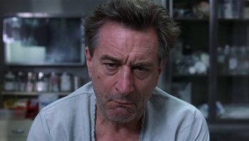 Movie still from “Analyze That” (2002), directed by Harold Ramis – A person wearing a white shirt; Close Up shot, Low angle