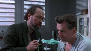 Movie still from “Analyze That” (2002), directed by Harold Ramis – Two men are talking in a room; Close Up shot, Over the shoulder angle