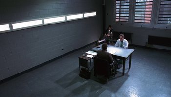 Movie still from “Analyze That” (2002), directed by Harold Ramis – Three people sitting at a table in a room; Wide shot, High angle