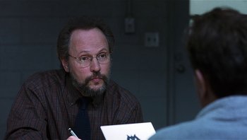 Movie still from “Analyze That” (2002), directed by Harold Ramis – A man sitting at a table in front of another man; Close Up shot, Over the shoulder angle