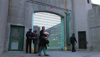 Movie still from “Analyze That” (2002), directed by Harold Ramis – A group of men standing around a gate; Wide shot, High angle