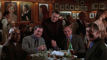 Movie still from “Analyze That” (2002), directed by Harold Ramis – A group of men sitting at a table in a restaurant; Wide shot, Low angle