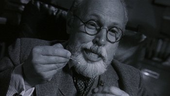 Movie still from “Analyze That” (2002), directed by Harold Ramis – An old man with a beard and glasses is putting a tooth pick in his mouth; Close Up shot, Low angle