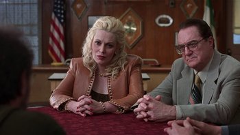 Movie still from “Analyze That” (2002), directed by Harold Ramis – A woman sitting at a table in front of two other people; Medium shot, Over the shoulder angle