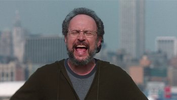 Movie still from “Analyze That” (2002), directed by Harold Ramis – A man with a beard and glasses is laughing; Close Up shot, Low angle
