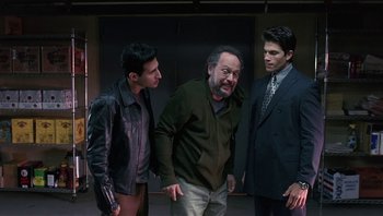 Movie still from “Analyze That” (2002), directed by Harold Ramis – A group of men standing next to each other in a room; Medium shot, Over the shoulder angle