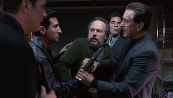 Movie still from “Analyze That” (2002), directed by Harold Ramis – A group of men fighting in a room with one holding a gun; Medium shot, Over the shoulder angle