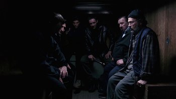 Movie still from “Analyze That” (2002), directed by Harold Ramis – A group of men sitting on a bus at night; Medium shot, High angle
