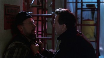 Movie still from “Analyze That” (2002), directed by Harold Ramis – Two men are talking in a dark room; Close Up shot, Over the shoulder angle