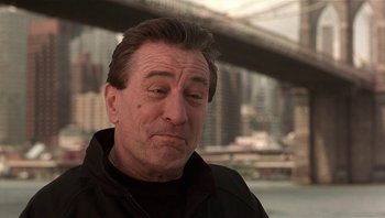 Movie still from “Analyze That” (2002), directed by Harold Ramis – A person wearing a black jacket; Close Up shot, Low angle