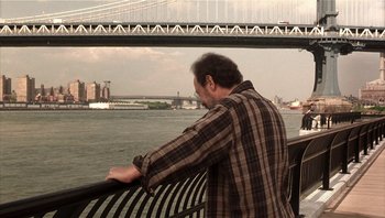 Movie still from “Analyze That” (2002), directed by Harold Ramis – A man leaning on a railing looking out at the water; Medium shot, Over the shoulder angle