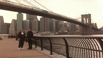 Movie still from “Analyze That” (2002), directed by Harold Ramis – Two people are standing on a pier near the water; Extreme Wide shot, High angle