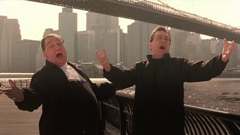 Movie still from “Analyze That” (2002), directed by Harold Ramis – Two men standing next to each other on a bridge; Medium shot, Low angle