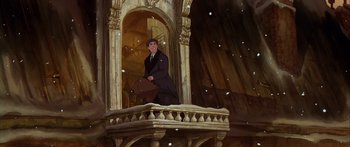 Movie still from “Anastasia” (1997), directed by Gary Goldman – A man standing on a balcony holding a briefcase; Wide shot, Low angle