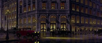 Movie still from “Anastasia” (1997), directed by Gary Goldman – A car parked on the side of the road next to a building; Extreme Wide shot, Low angle