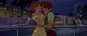 Movie still from “Anastasia” (1997), directed by Gary Goldman – A man and a woman kissing in front of a bridge at night; Medium shot, Low angle