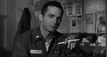 Movie still from “Anatomy of a Murder” (1959), directed by Otto Preminger – Black and white photograph of a man holding a toothbrush; Close Up shot, Low angle