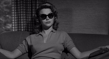 Movie still from “Anatomy of a Murder” (1959), directed by Otto Preminger – A black and white photo of a woman wearing sunglasses; Medium shot, Low angle