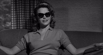 Movie still from “Anatomy of a Murder” (1959), directed by Otto Preminger – A black and white photo of a woman wearing sunglasses; Medium shot, Low angle