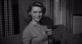 Movie still from “Anatomy of a Murder” (1959), directed by Otto Preminger – A black and white photo of a woman holding a drink; Medium shot, Over the shoulder angle