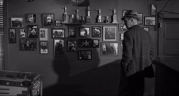 Movie still from “Anatomy of a Murder” (1959), directed by Otto Preminger – A black and white photo of a man in a suit and hat; Medium shot, Over the shoulder angle