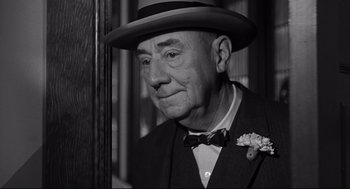 Movie still from “Anatomy of a Murder” (1959), directed by Otto Preminger – An older man wearing a hat and a bow tie; Close Up shot, Low angle