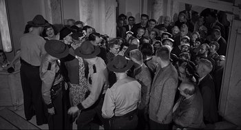 A group of people standing around each other in a room