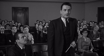 Movie still from “Anatomy of a Murder” (1959), directed by Otto Preminger – A black and white photo of a man in a suit and tie; Medium shot, Low angle