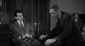Movie still from “Anatomy of a Murder” (1959), directed by Otto Preminger – Two men in suits and ties sitting next to each other in a room; Medium shot, Over the shoulder angle