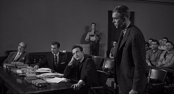 Movie still from “Anatomy of a Murder” (1959), directed by Otto Preminger – A group of men sitting at a table in a room; Medium shot, Over the shoulder angle
