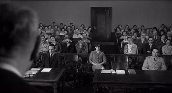 Movie still from “Anatomy of a Murder” (1959), directed by Otto Preminger – A group of people sitting in front of each other in a room; Wide shot, High angle