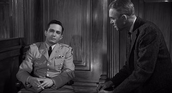 Movie still from “Anatomy of a Murder” (1959), directed by Otto Preminger – Two men are sitting next to each other in a courtroom; Medium shot, Over the shoulder angle