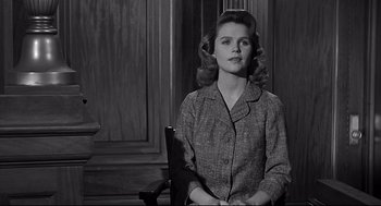 Movie still from “Anatomy of a Murder” (1959), directed by Otto Preminger – A woman sitting on a chair in a room; Medium shot, Low angle