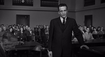 Movie still from “Anatomy of a Murder” (1959), directed by Otto Preminger – A black and white photo of a man in a suit and tie; Medium shot, Low angle
