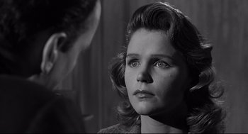 Movie still from “Anatomy of a Murder” (1959), directed by Otto Preminger – A black - and - white photo of a woman looking at a man; Close Up shot, Over the shoulder angle