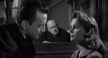 Movie still from “Anatomy of a Murder” (1959), directed by Otto Preminger – A man and a woman face each other in front of a judge; Close Up shot, Over the shoulder angle