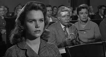 Movie still from “Anatomy of a Murder” (1959), directed by Otto Preminger – An old photo of people sitting in a room; Close Up shot, Over the shoulder angle