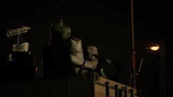 Movie still from “Snowfall” (2017), directed by Hiro Murai – A statue is sitting on top of a building; Extreme Wide shot, Low angle