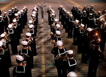 Movie still from “Anchors Aweigh” (1945), directed by Joseph Barbera – A group of men in black and white uniforms standing next to each other; Extreme Wide shot, High angle