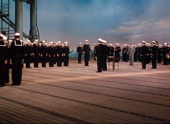Movie still from “Anchors Aweigh” (1945), directed by Joseph Barbera – A group of sailors standing on a deck; Extreme Wide shot, High angle